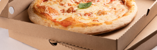 Piza w pudełku otwarty, które leży na dwóch kartonach wykrojnikowych do pizzy